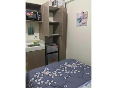 a small room with a bed with a blue blanket with flowers at Shanilyn Residency Urban Deca Towers EDSA Mandaluyong,UNLIMITED INTERNET AND NETFLIX in Manila