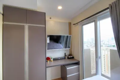 a bedroom with a tv and a large window at Makati - Chino Roces Trevi Towers in Manila