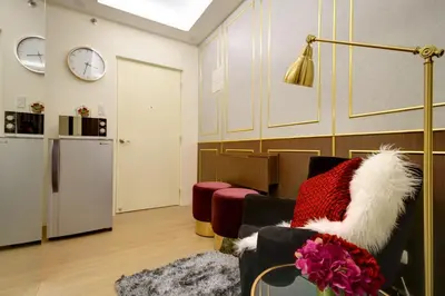a living room with a chair and a refrigerator at Makati - Chino Roces Trevi Towers in Manila