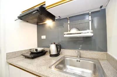 a kitchen counter with a sink and a stove at Makati - Chino Roces Trevi Towers in Manila