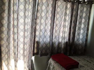 a bedroom with curtains and a bed in front of a window at Best Value Q Condo1439 in Manila
