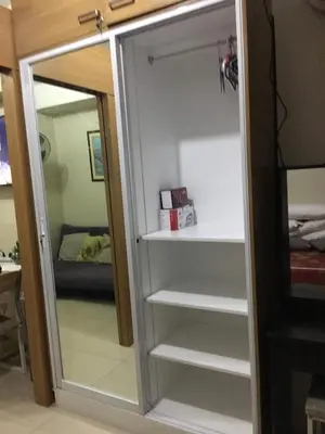 a sliding glass door with a mirror in a room at Best Value Q Condo1439 in Manila