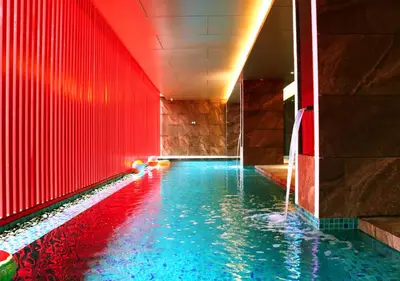 a swimming pool with red walls and blue water at Red Hotel Cubao, Quezon City in Manila