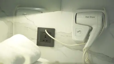 a hair dryer and an electrical outlet on a wall at Red Hotel Cubao, Quezon City in Manila
