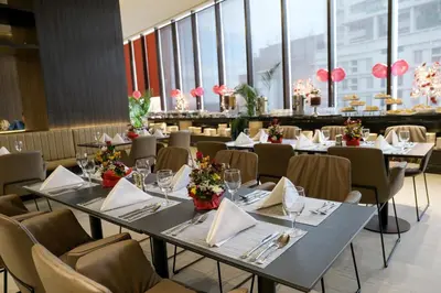 a dining room with tables and chairs and windows at Red Hotel Cubao, Quezon City in Manila