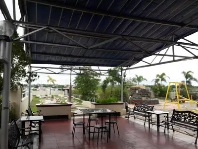 a patio with tables and chairs under a blue roof at EKONUMI ROOMS at Moonwalk Paranaque in Manila