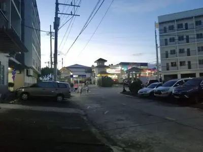 a city street with cars parked in a parking lot at EKONUMI ROOMS at Moonwalk Paranaque in Manila