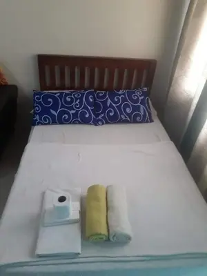 a bed with two rolls of toilet paper on it at EKONUMI ROOMS at Moonwalk Paranaque in Manila