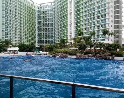 a large swimming pool in front of tall buildings at Azure Staycation Near Airport in Manila