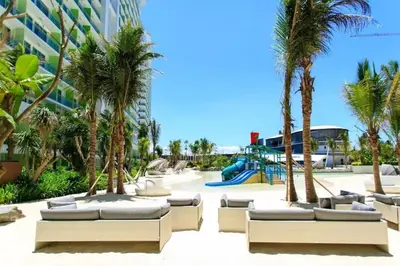 a resort with palm trees and a playground at Azure Staycation Near Airport in Manila