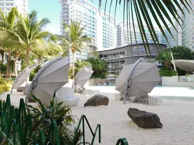 a group of umbrellas on a beach with buildings at Azure Staycation Near Airport in Manila