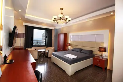 a hotel room with a bed and a desk and a room at Malate Bayview Mansion city view in Manila