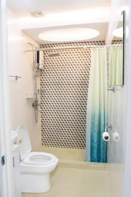 a bathroom with a toilet and a shower at Malate Bayview Mansion city view in Manila
