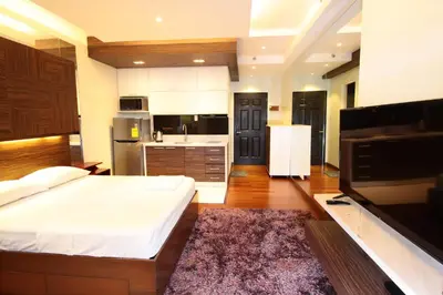 a large bedroom with a large bed and a kitchen at Malate Bayview Mansion city view in Manila