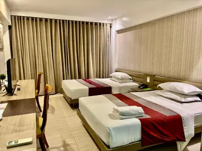 a hotel room with two beds and a desk at The E-Hotel Makati in Manila