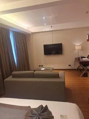 a living room with a couch and a flat screen tv at ACE Hotel and Suites in Manila