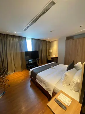 a bedroom with a large bed and a television at ACE Hotel and Suites in Manila