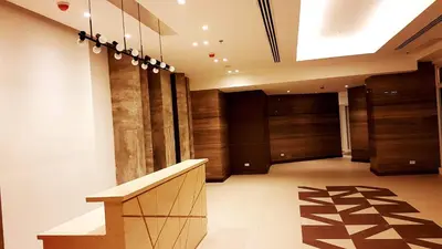 a hallway with wooden doors and a bench in a building at Studio Fully Furnished in Manila