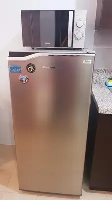 a microwave sitting on top of a refrigerator at Studio Fully Furnished in Manila