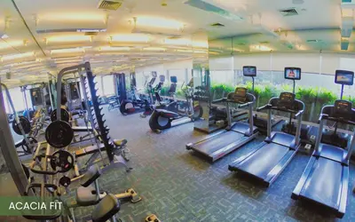a gym with several treadmills and cardio machines at Acacia Hotel Manila in Manila