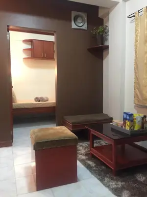 a living room with a bed and a table at Las Pinas Serviced Apartment in Manila
