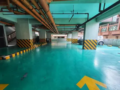 an empty parking garage with blue floors and yellow arrows at SweetSuites at Pine Crest #T3-239 in Manila