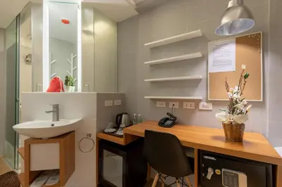 a bathroom with a sink and a desk with a sink at Selah Pods Hotel Manila in Manila