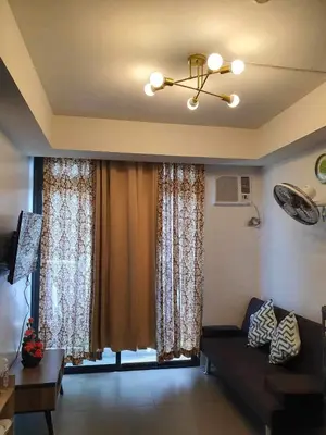 a living room with a couch and a large window at A Home with a view, 1 Bdrm with balcony and Netflix Access in Manila