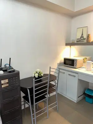 a small kitchen with a table and a microwave at A Home with a view, 1 Bdrm with balcony and Netflix Access in Manila