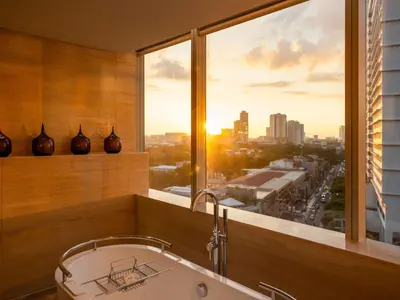 a bathroom with a tub and a large window at Fairmont Makati in Manila