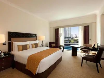 a hotel room with a large bed and a desk and a desk at Fairmont Makati in Manila