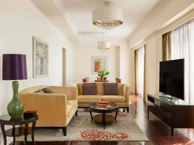 a living room with a couch and a tv at Raffles Makati in Manila