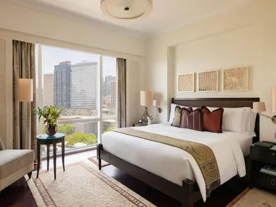a bedroom with a large bed and a large window at Raffles Makati in Manila