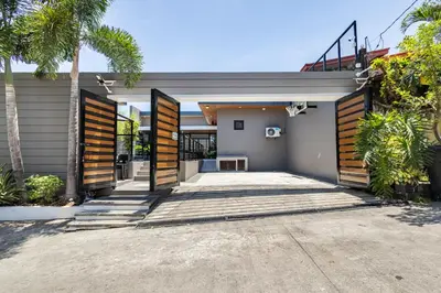 a home with wooden doors and a driveway at Addie's Place Soldiers Hills Village Muntinlupa in Manila