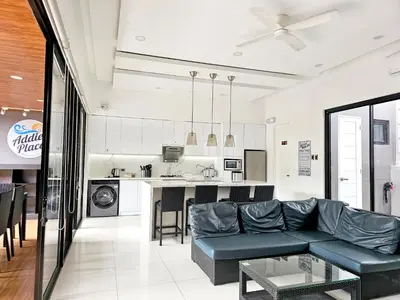 a living room with a couch and a kitchen at Addie's Place Soldiers Hills Village Muntinlupa in Manila