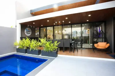 a house with a swimming pool and a dining area at Addie's Place Soldiers Hills Village Muntinlupa in Manila