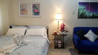 a bedroom with a bed and a blue chair at Jen's Paranaque City Apartment in Manila