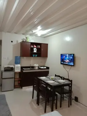 a small kitchen with a table and chairs in a room at Jen's Paranaque City Apartment in Manila