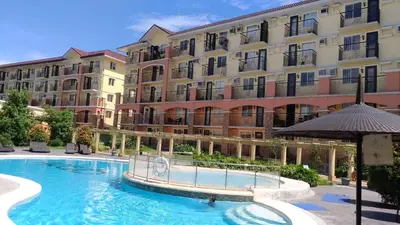 a swimming pool in front of a large building at The Escape Pad 1 by Sharon May in Manila