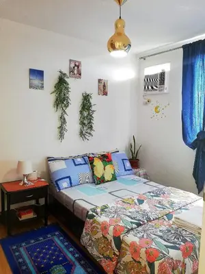a bedroom with a bed and a table with a lamp at The Escape Pad 1 by Sharon May in Manila