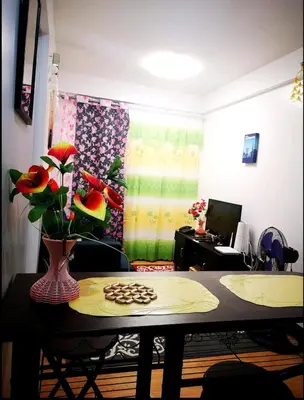 a room with a table with a vase of flowers at The Escape Pad 1 by Sharon May in Manila
