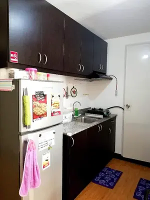 a kitchen with a white refrigerator and a sink at The Escape Pad 1 by Sharon May in Manila