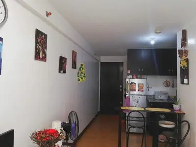 a kitchen with a table and a kitchen with a refrigerator at The Escape Pad 1 by Sharon May in Manila