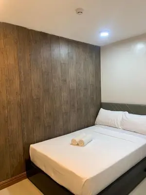 a bedroom with a bed with two towels on it at Maine City Residences in Manila