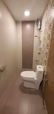 a bathroom with a toilet and a shower at Maine City Residences in Manila