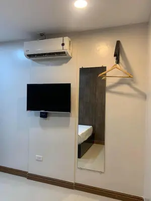 a wall with a tv and a mirror in a room at Maine City Residences in Manila
