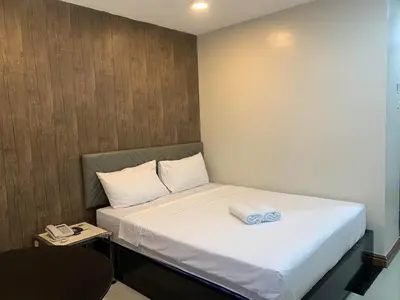 a small bedroom with a bed with white sheets at Maine City Residences in Manila