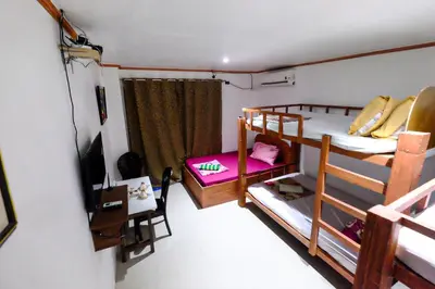 a room with two bunk beds and a television at Bing's Place in Manila