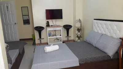 a bedroom with a large bed and a television at Bing's Place in Manila