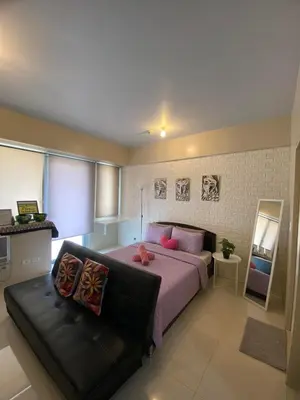 a bedroom with a bed and a couch at Modern Studio Unit at One Palm Tree Villas near NAIA & Resortsworld in Manila